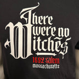 Close up of a graphic tee shirt with red and white lettering that reads There were no Witches 1692 Salem Massachusetts