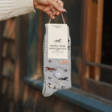 Gray socks with horse designs held by a hand, branded 'conscious step'.